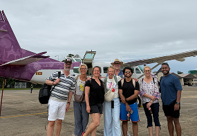 Group photo beside a small aircraft